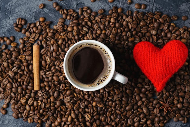 Taza de café con un corazón y granos de café.