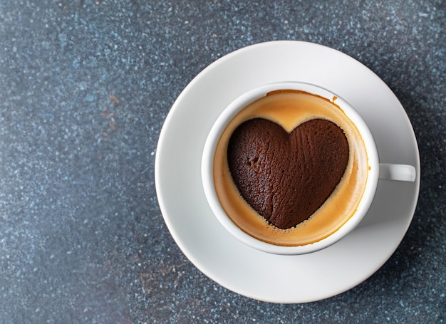 taza de café con un corazón en un plato con pastel