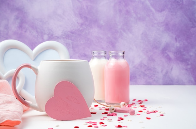 Taza de café y corazón rosa sobre un fondo romántico.