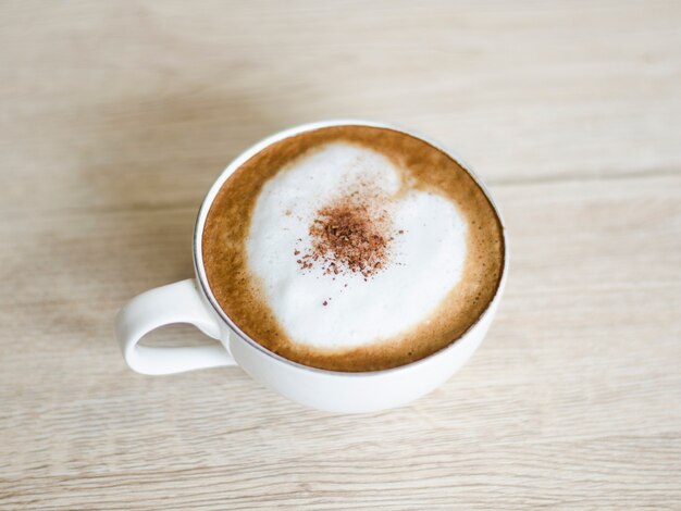 Taza de café con corazones en la mesa vieja