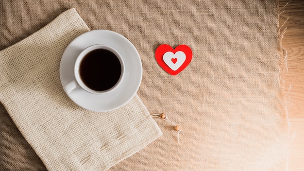 Taza de café y corazones en texturas de cilicio.