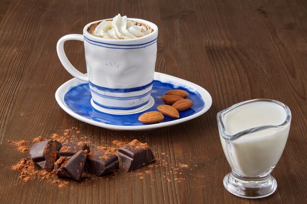 Taza de café con crema batida y almendras