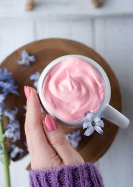 Una taza de café con crema y flores.