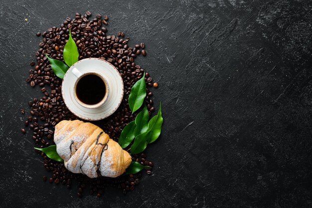 Taza de café con croissant Desayuno Sobre un fondo de piedra negra Vista superior Espacio libre para su texto