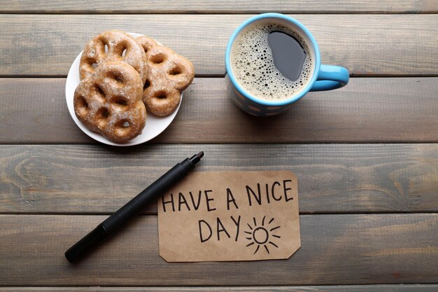 Taza de café con croissant recién hecho y masaje Have A Nice Day en la  vista superior de la mesa de madera | Foto Premium
