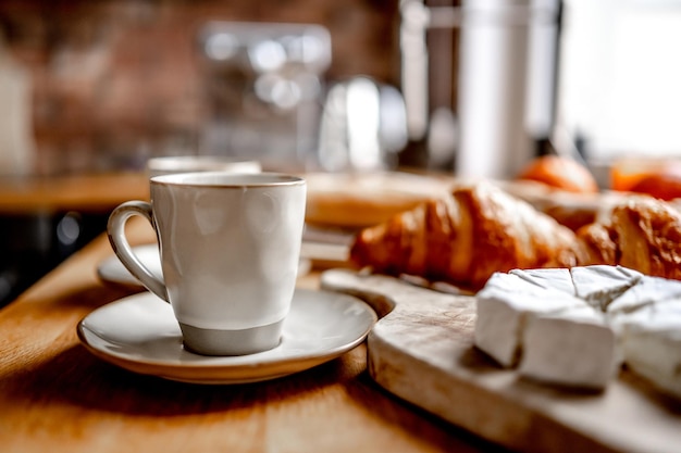 Taza de café y croissants en la mesa de la cocina