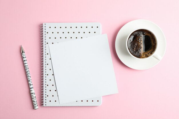 Taza de café con cuaderno y bolígrafo, vista superior