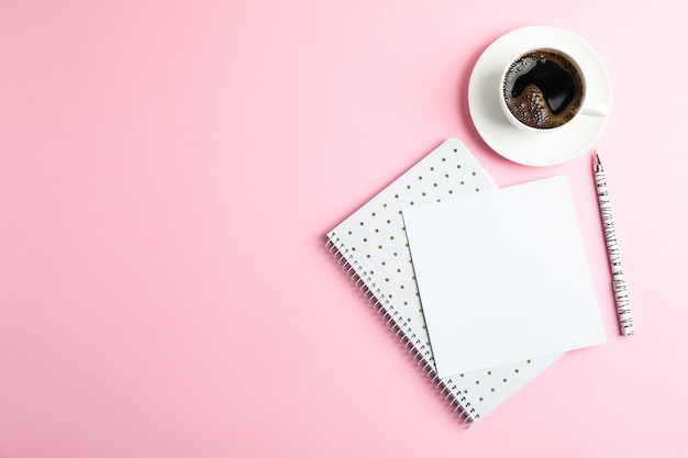 Taza de café con cuaderno y bolígrafo