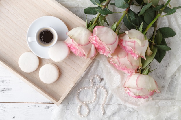 Taza de café, cuaderno y flores rosas. Clásico.