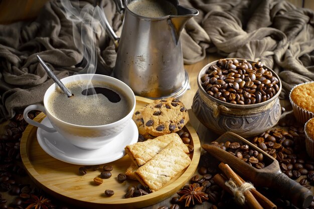 Una taza de café con una cuchara y granos de café sobre una mesa.