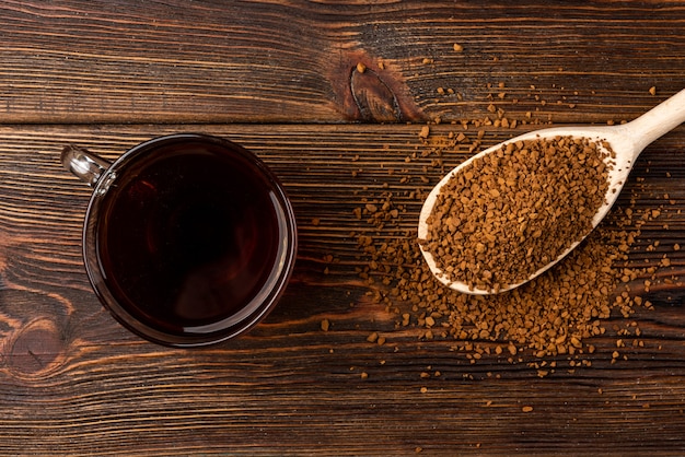 Taza de café y cuchara de madera con café granulado