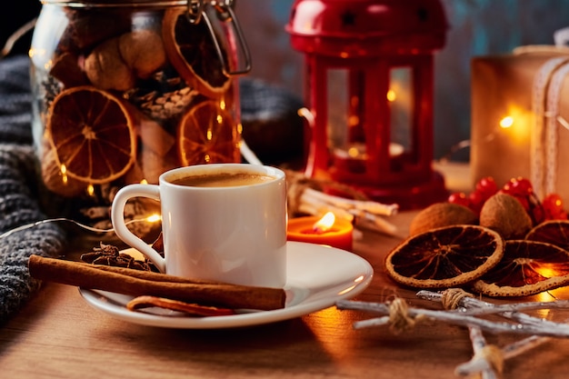 Taza de café en decoraciones festivas con una guirnalda de luces de hadas