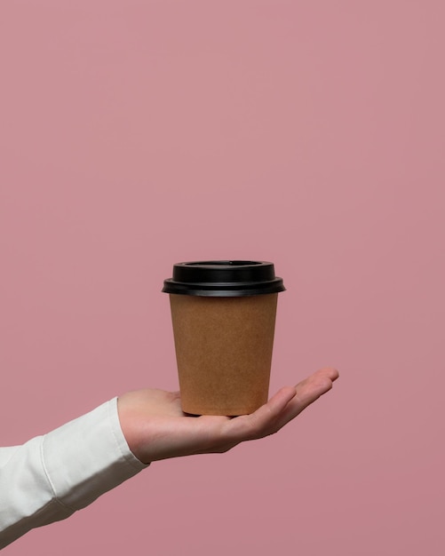 taza de café desechable en la mano Mockup