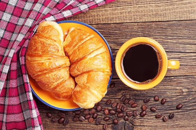 Taza de café y dos croissants.