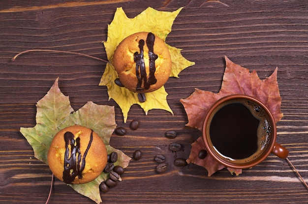 Taza de café y dos cupcakes con chocolate.