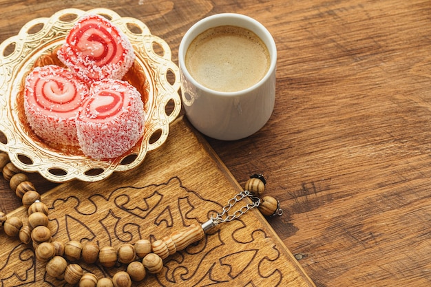 Taza de café con dulces orientales en la mesa de madera de cerca