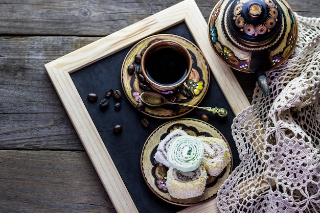 Taza de café y dulces en un plato sobre la mesa