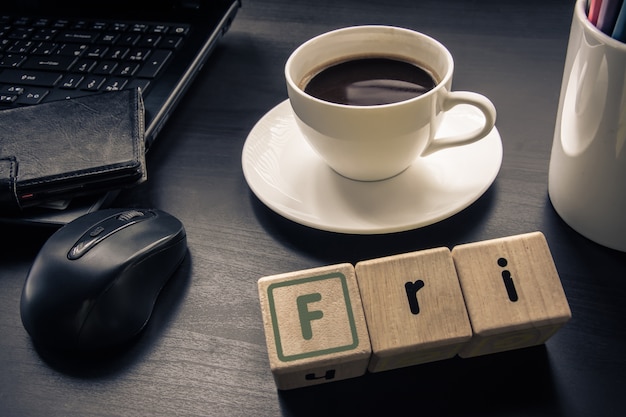 taza de café en el escritorio con madera cubo Clasificar por día