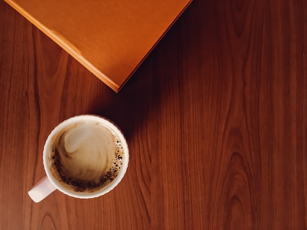 Taza de café en el escritorio de madera, fondo plano y maqueta de negocios, vista superior