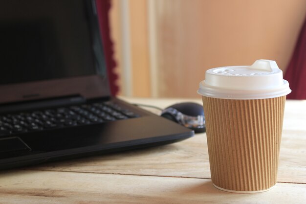 taza de café y escritorio de oficina con computadora portátil