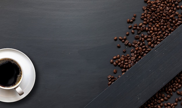 Taza de café en el espacio de vista superior de fondo de piso de madera negra para texto