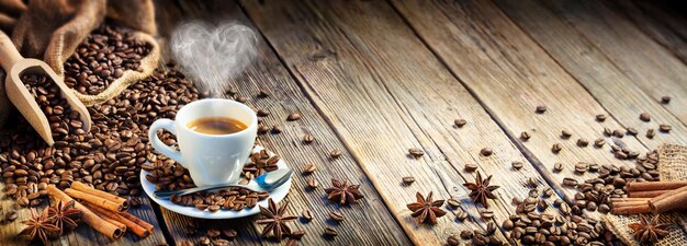 Foto taza de café espresso con frijoles y canela en una mesa de madera