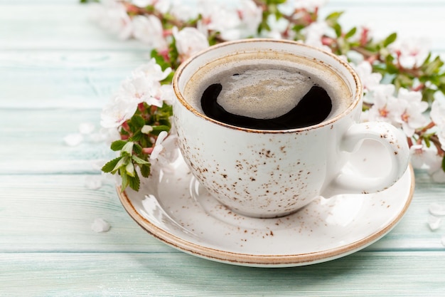 Taza de café espresso matutino y flor de cerezo