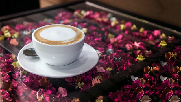 Taza de café en espuma de café con leche de flores en taza de café