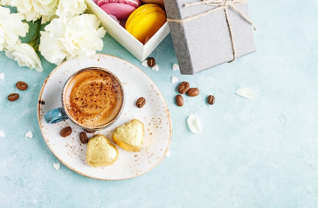 Taza de café con espuma y dulces de chocolate