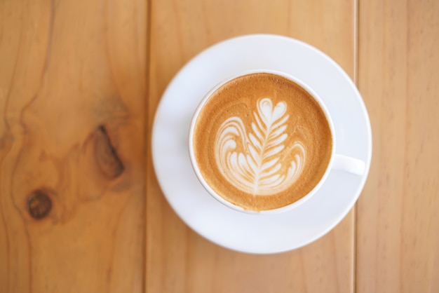 Taza de café con espuma de leche de helecho árbol patrón