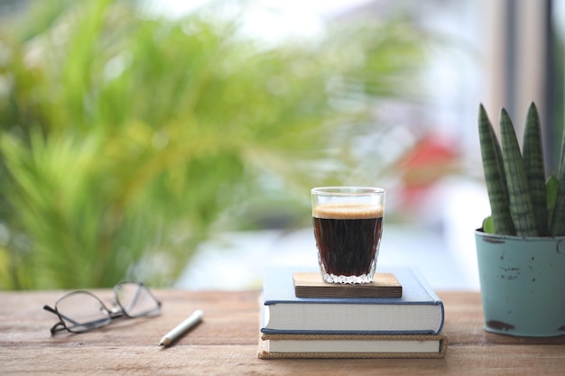 Taza de café expreso y cuaderno y vasos y maceta