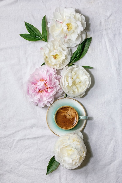 Taza de café expreso, flores de peonías rosas y blancas con hojas. Lay Flat, espacio de copia