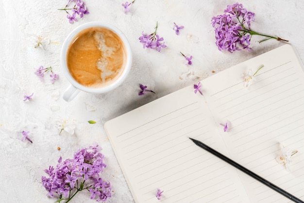 Taza de café, flores y libreta