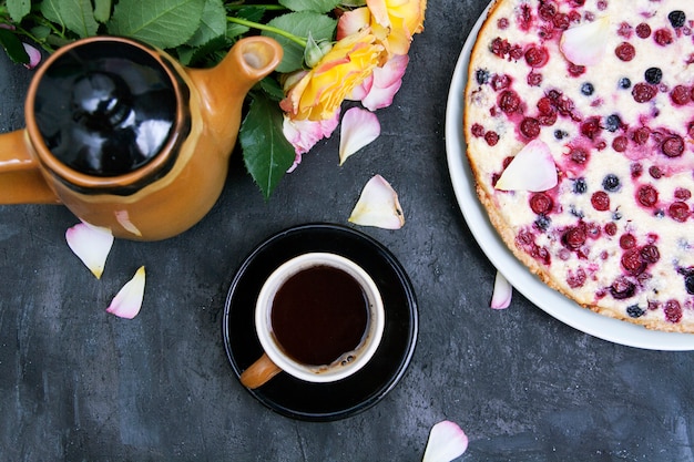 Taza de café con flores y pastel de bayas