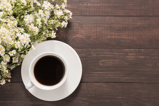 Una taza de café con flores sobre fondo de madera