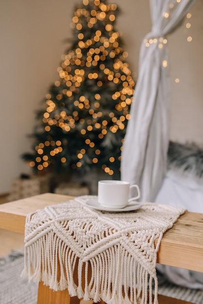 Taza de café en el fondo del árbol de Navidad foto vertical