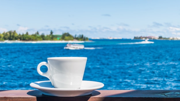 Taza de café con fondo hermoso paisaje marino