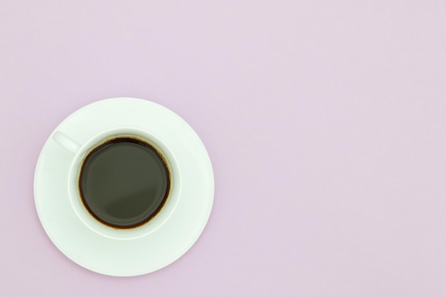 Una taza de café con un fondo morado.