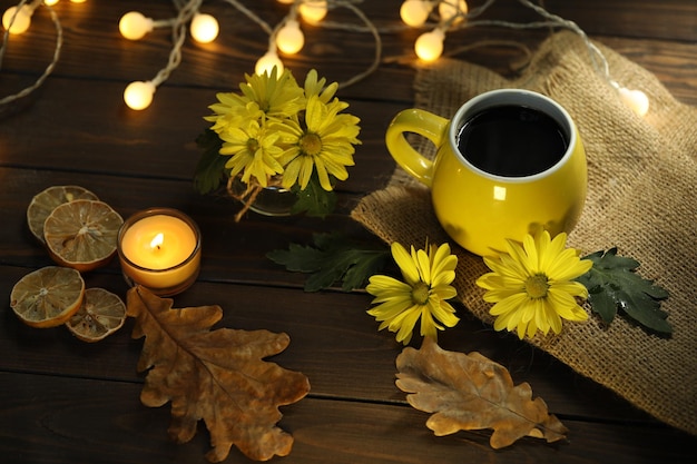 taza de café en el fondo de otoño con hojas y flores