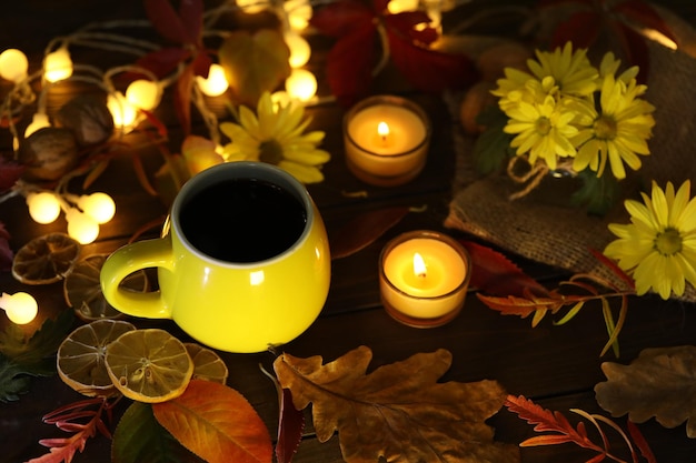 taza de café en el fondo de otoño con hojas y flores