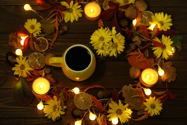 taza de café en el fondo de otoño con hojas y flores