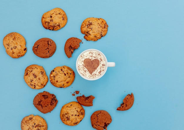 Taza de café con forma de corazón y galletas