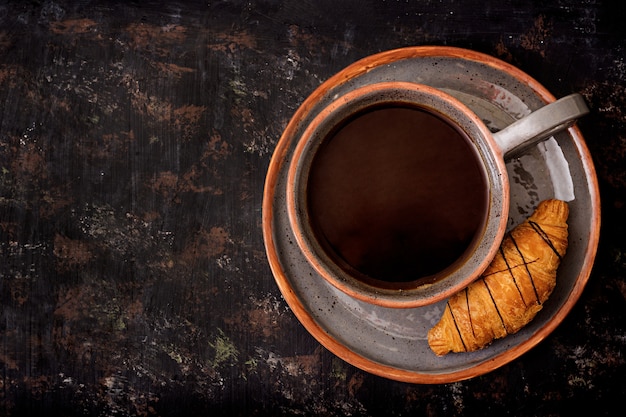 Una taza de café fragante y un croissant. Desayuno de la mañana Endecha plana. Vista superior