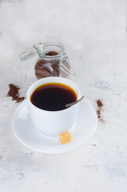 Taza de café y un frasco de vidrio con café en polvo