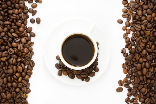 Taza de café y frijoles aislados en un fondo blanco.