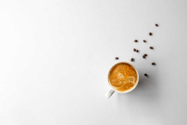 Taza de café y frijoles al lado