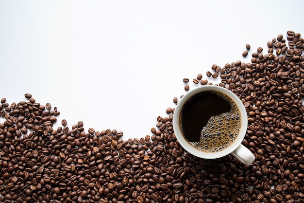 Taza de café y frijoles en el cuadro blanco