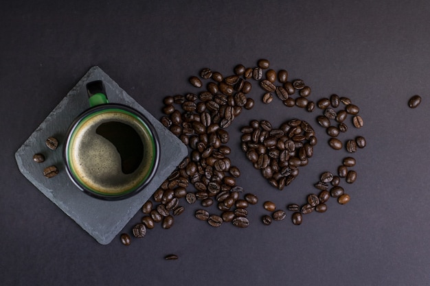 Taza de café con frijoles en un fondo oscuro