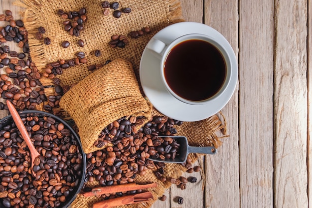 Taza de café y frijoles en la mesa de madera vieja