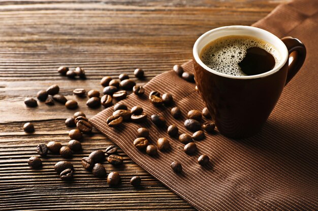 Taza de café con frijoles en la mesa de madera